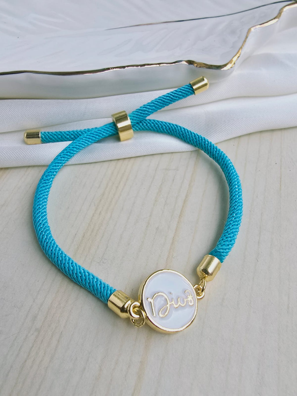 Pulsera cordón con dije en rodio y circones