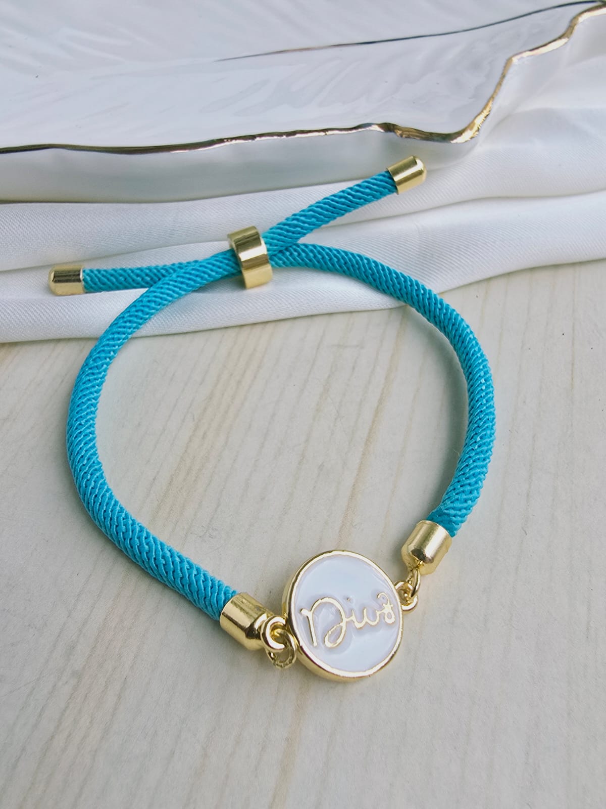 Pulsera cordón con dije en rodio y circones